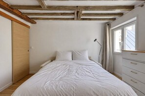 Ein Schlafzimmer mit einem Bett, einem Kleiderschrank und einem Fenster.