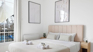 A neatly made bed with rolled towels and toiletries, a bedside table with a lamp, and artwork on the walls. - Studio d'Architecte avec Cheminee - Design -4 personnes (Paris)