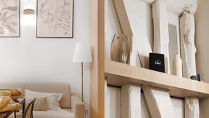 A modern living room with a sofa, a coffee table, and two framed artworks. - Duplex d'Exception avec climatisation - Rue Monge (Paris)