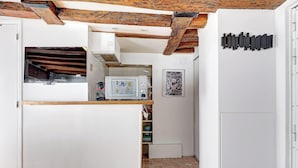 Una cucina angusta con travi in legno a vista, un forno a microonde vintage e un piccolo frigorifero.