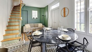 Un'area pranzo con un tavolo rotondo, sedie e una scala a chiocciola.