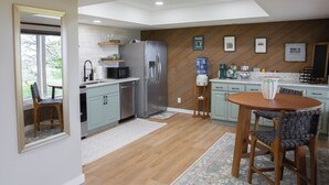 A modern kitchen with a refrigerator, sink, and wooden dining table. - Vineyard 1 bedroom apartment in West Salem - Gorgeous Views. (Salem)
