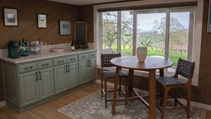 A kitchen with a dining table and chairs, a large window with a view of the countryside, and a wooden floor. - Vineyard 1 bedroom apartment in West Salem - Gorgeous Views. (Salem)