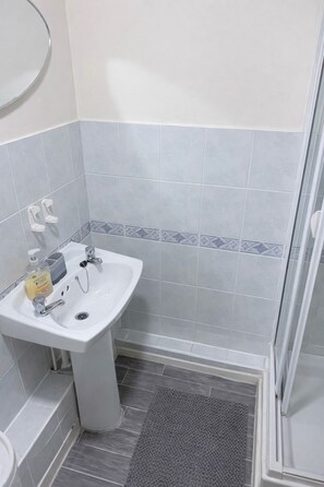 Een douche, handdoeken, toiletpapier