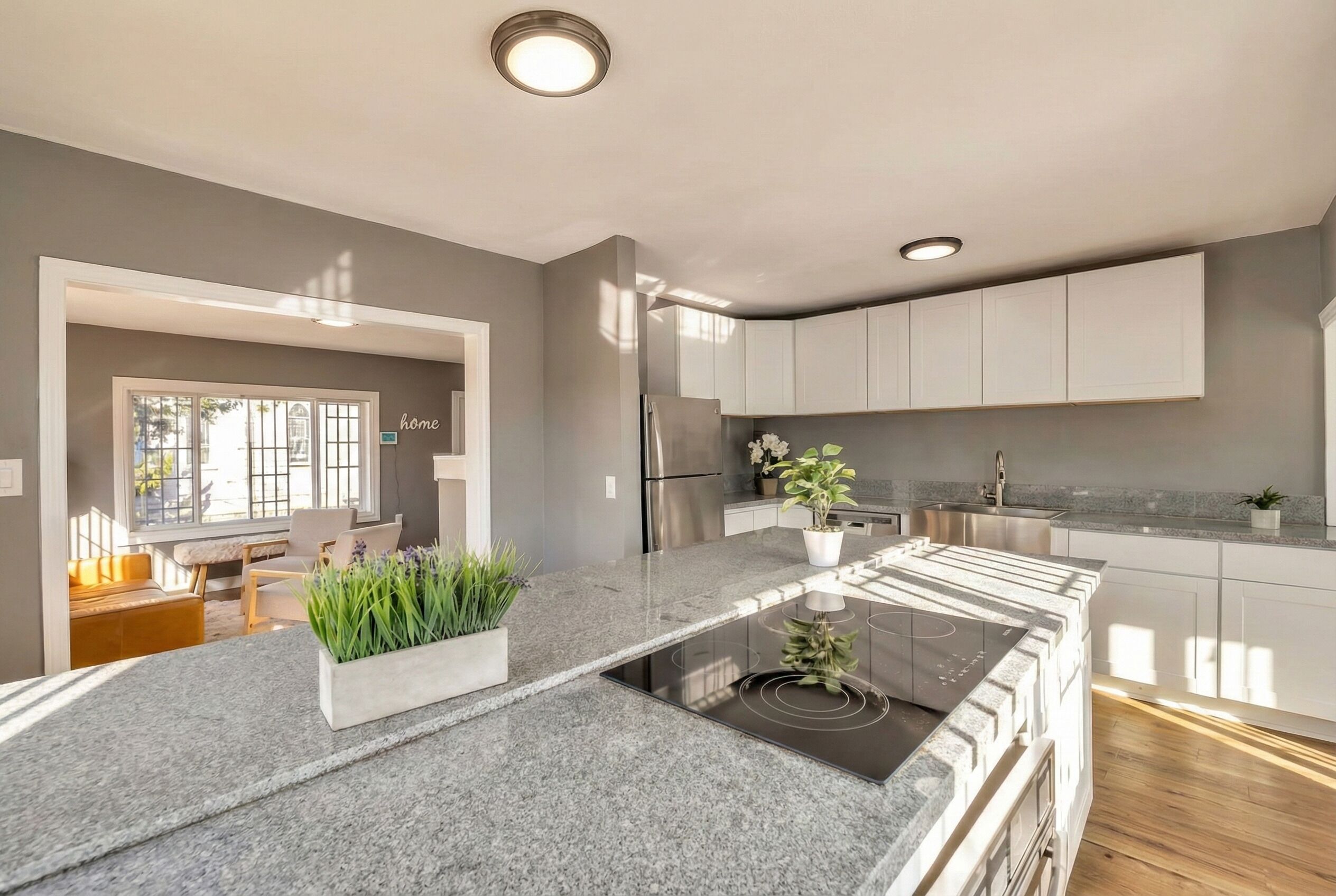 Una cocina moderna con una isla central, electrodomésticos integrados y vista al área de estar.