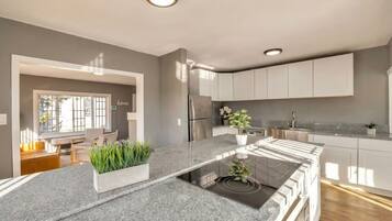 Una cocina moderna con una isla central, electrodomésticos integrados y vista al área de estar.
