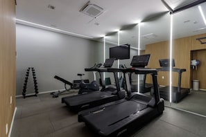 A modern gym with treadmills, a stationary bike, and weight machines. - Studio 402 Perdizes 900m Allianz Parque c Academia (São Paulo)
