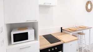 Una cucina moderna con forno a microonde, piano cottura e un piano di lavoro in legno.