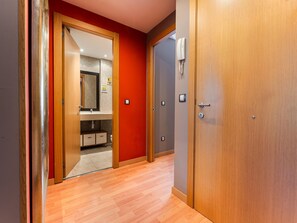 Een hotelkamer met een houten deur, een badkamer met een spiegel en een toilet.