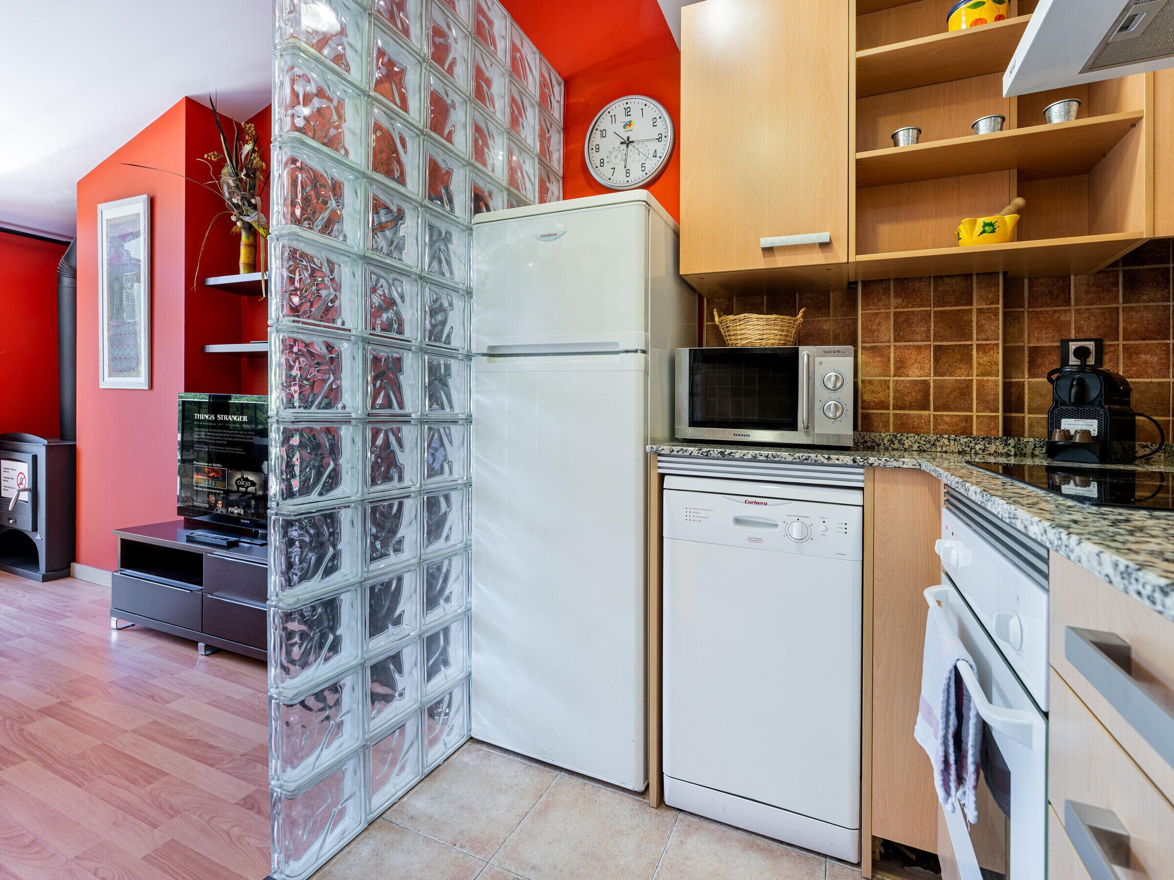 Eine kleine Küche mit Kühlschrank, Mikrowelle und Backofen.