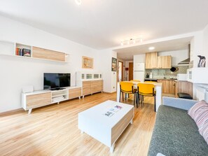 En moderne lejlighed med opholdsstue, spiseplads og køkken.