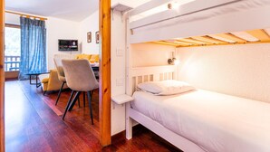 Une chambre avec un lit superposé, un bureau et une chaise.