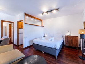 A hotel room with a bed, bedside table, lamp, and a chair. - Panoramic Studio in El Tarter with Parking - 4 pax (El Tarter)