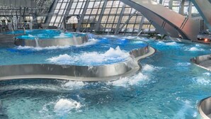 Un élément décoratif aquatique intérieur composé de plusieurs niveaux et de cascades.