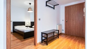 A bedroom with a bed, bedside table, and a hanging drying rack. - Arinsal Apartment 4 pers, 2 bdrm, elevator, near lift (Arinsal)