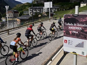 Des cyclistes sur une route, avec un panneau indiquant le col de la Collada de Beixalís en Andorre.