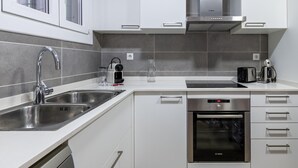 Una cocina moderna con electrodomésticos de acero inoxidable, lavavajillas y horno empotrado.