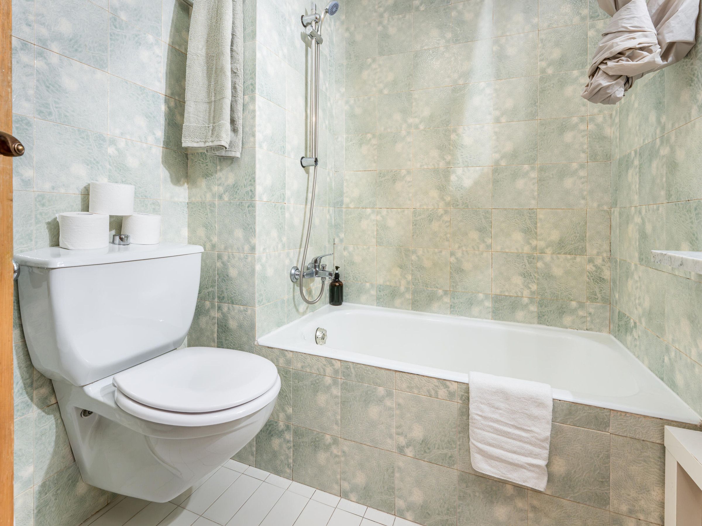 Une salle de bain avec des toilettes, une douche et une baignoire.