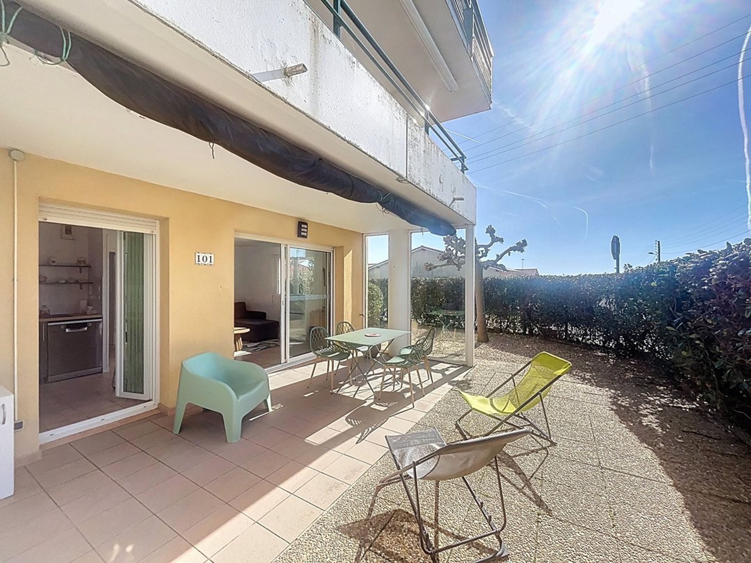 A residential property with a patio area, a sliding glass door entrance, and a number sign indicating the unit.