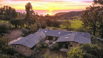 Uma casa com telhado inclinado, painéis solares e um espaço de varanda.