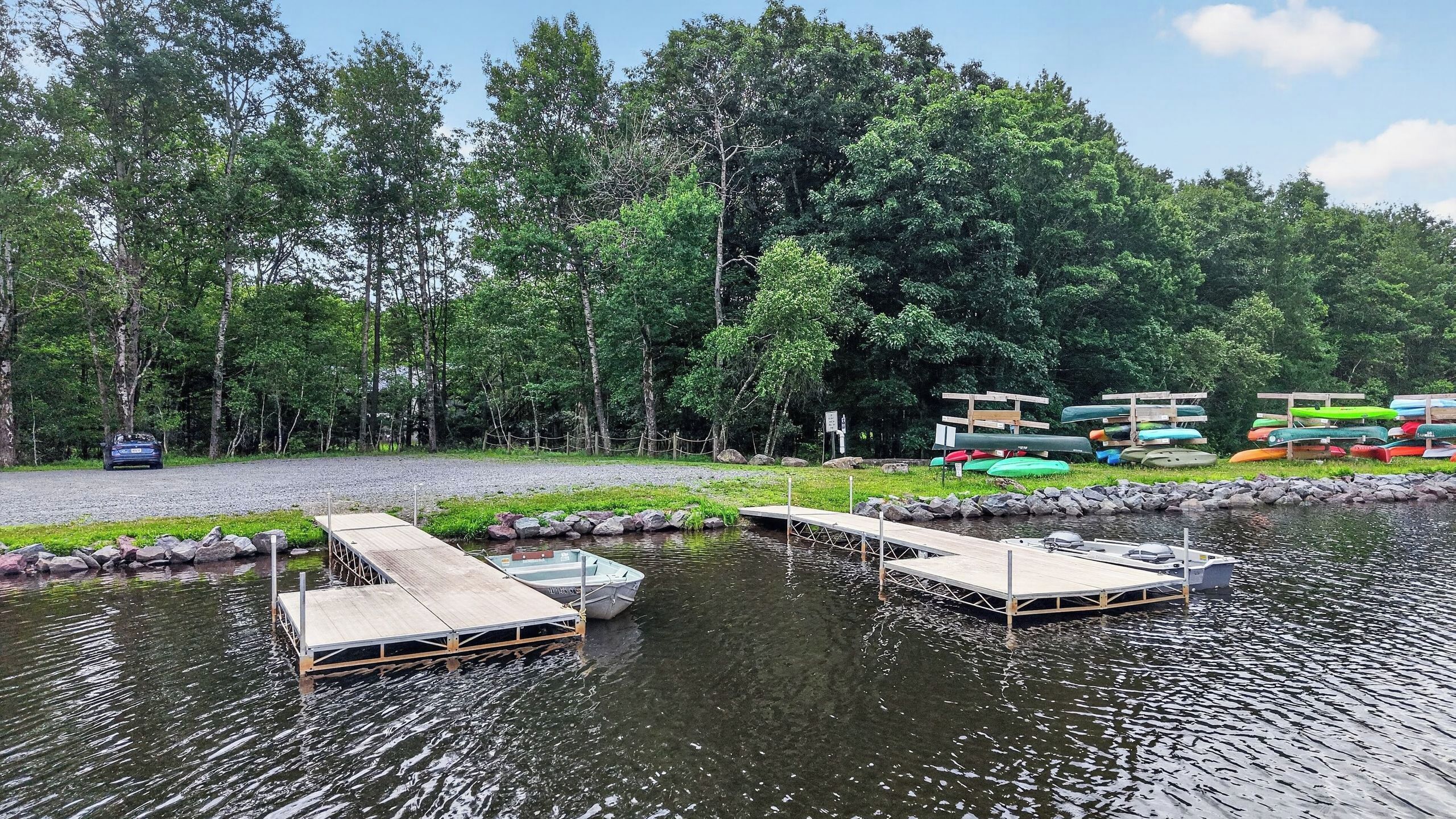 A calm lake with wooden docks, surrounded by dense trees.