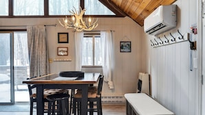 A dining area with a wooden table, chairs, a chandelier, and a bench. - Evergreen Lodge by Avantstay Poconos Lake Cabin + Fireplace + Large Deck + Near Jack Frost & Kalahari (Pocono Lake)