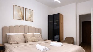 Une chambre à coucher moderne avec un grand lit, une armoire et un luminaire fixé au plafond.