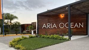 A modern building with a sign reading "ARIA OCEAN". - Océano Aria, Entire Lodging: Condominium in Bucerias, Mexico (Nuevo Vallarta)