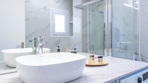 A modern bathroom with two large white sinks, a glass shower enclosure, and a marble backsplash. - Terrace Dreams w/Pasalimani View - 2 minutes of walk distance (Pireas)