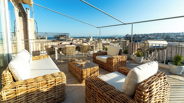 A rooftop terrace with wicker furniture, a dining area, and potted plants. - Terrace Dreams w/Pasalimani View - 2 minutes of walk distance (Pireas)