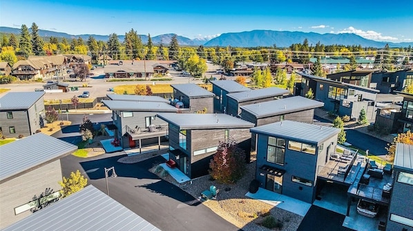 A modern residential area with contemporary houses, a central courtyard, and a mountain backdrop.