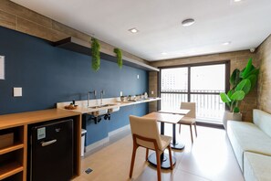 Eine moderne Küche mit integriertem Kühlschrank, Spüle und Essbereich inklusive Tisch und Stühlen.