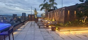 A rooftop terrace with lounge chairs, a table, and a view of the cityscape. - Apartment in downtown Rio, across from the Carioca subway station, near Lapa. (Rio de Janeiro)