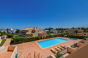 Un complexe hôtelier doté d’une piscine, de chaises longues et offrant une vue sur le paysage environnant.