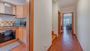 Una cocina con electrodomésticos modernos, un comedor con vistas y un pasillo que conduce a una sala de estar.