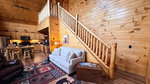 Ein Holzblock-Interieur mit Küche, Wohnbereich und Treppe.