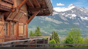 A wooden chalet with a balcony overlooking a snow-capped mountain. - Chalet Uska - Enjoy the thrill of the Alps all year round - OVO Network (Combloux)