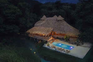 A thatched-roof structure with a pool and lounge chairs. - El Valle lodge (Samana)