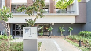 A modern building with a sign that reads "ESSENTIAL PERDIZES HOME". - Studio 407 Perdizes 900m Allianz Parque c Academia (São Paulo)