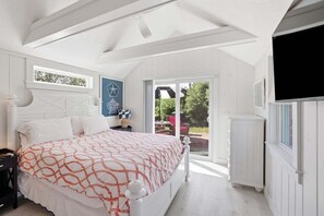 Ein Schlafzimmer mit einem großen Bett, einem Fenster und Blick ins Freie.