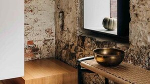 Une pièce au style rustique, avec des murs en briques apparentes, une grande fenêtre et un plancher en bois.