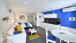 Ein modernes Apartment mit Wohnzimmer, Küche und Essbereich.