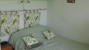 A bedroom with a bed, green headboard, and a nightstand. - Studio Héliopolis E 20 - 2 people (AGDE)