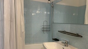 Une salle de bain avec une baignoire, un lavabo et une douche.