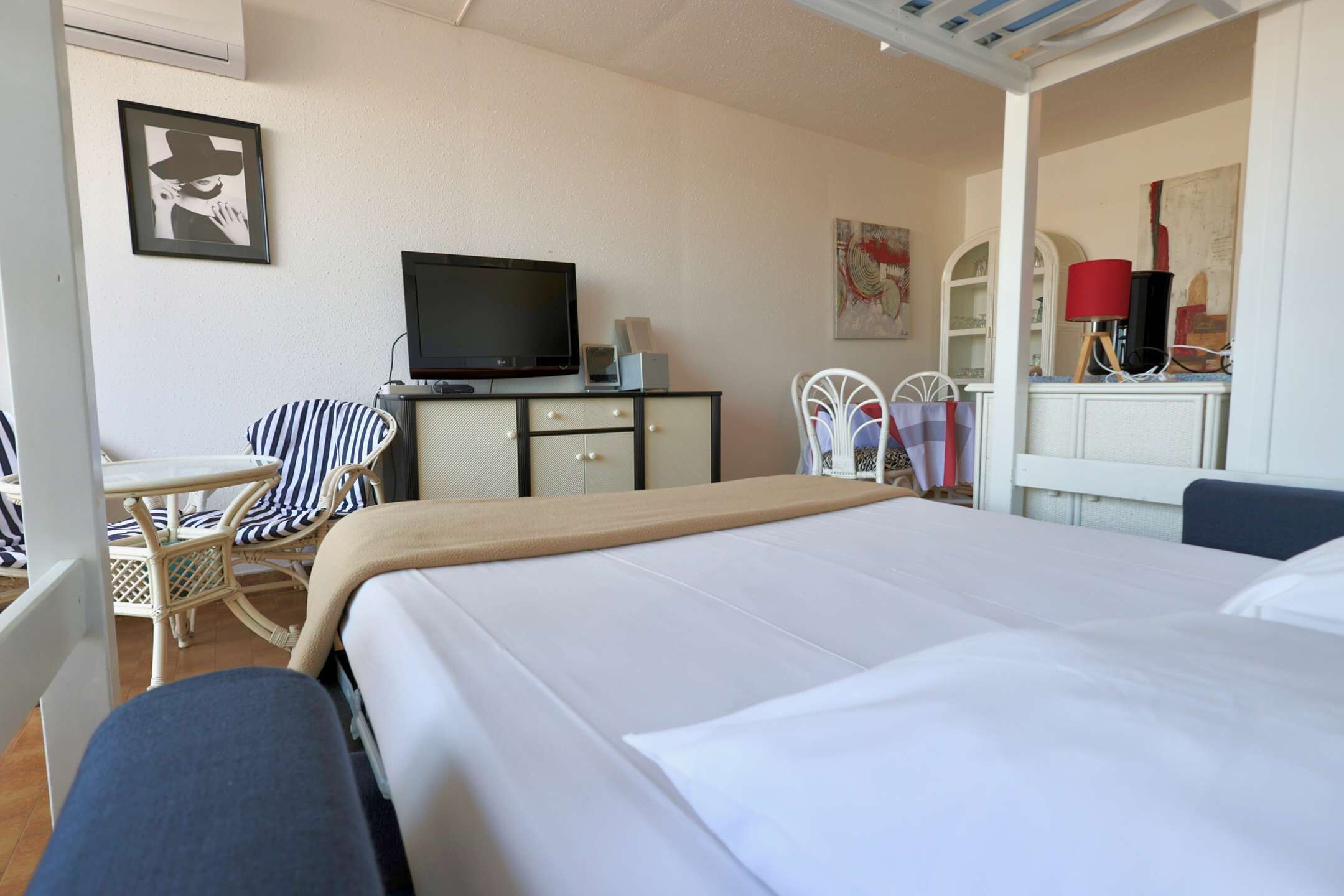Une chambre d’hôtel comprenant un lit, une télévision, un bureau avec une chaise et une petite table.
