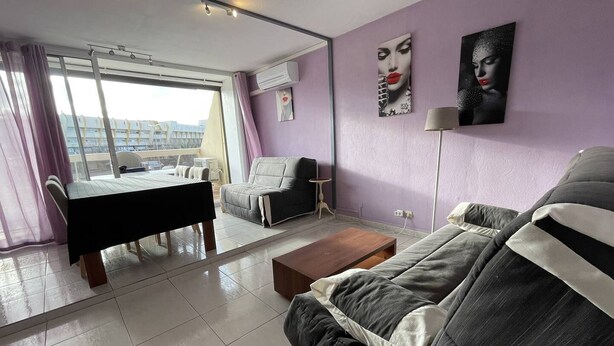 A modern living room with a sofa, a dining table, and a coffee table. - Apartment Héliopolis E 78 - 4 people (AGDE)