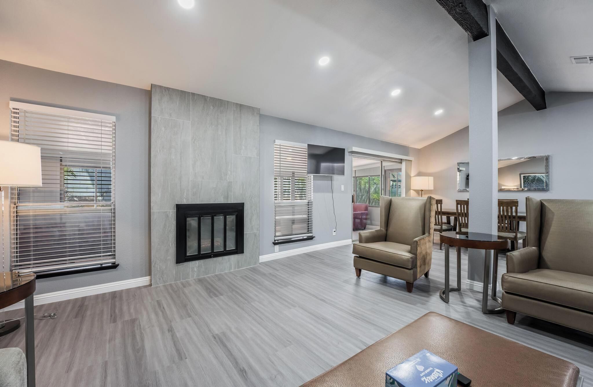 A spacious living room with a fireplace, comfortable seating, and a dining area.