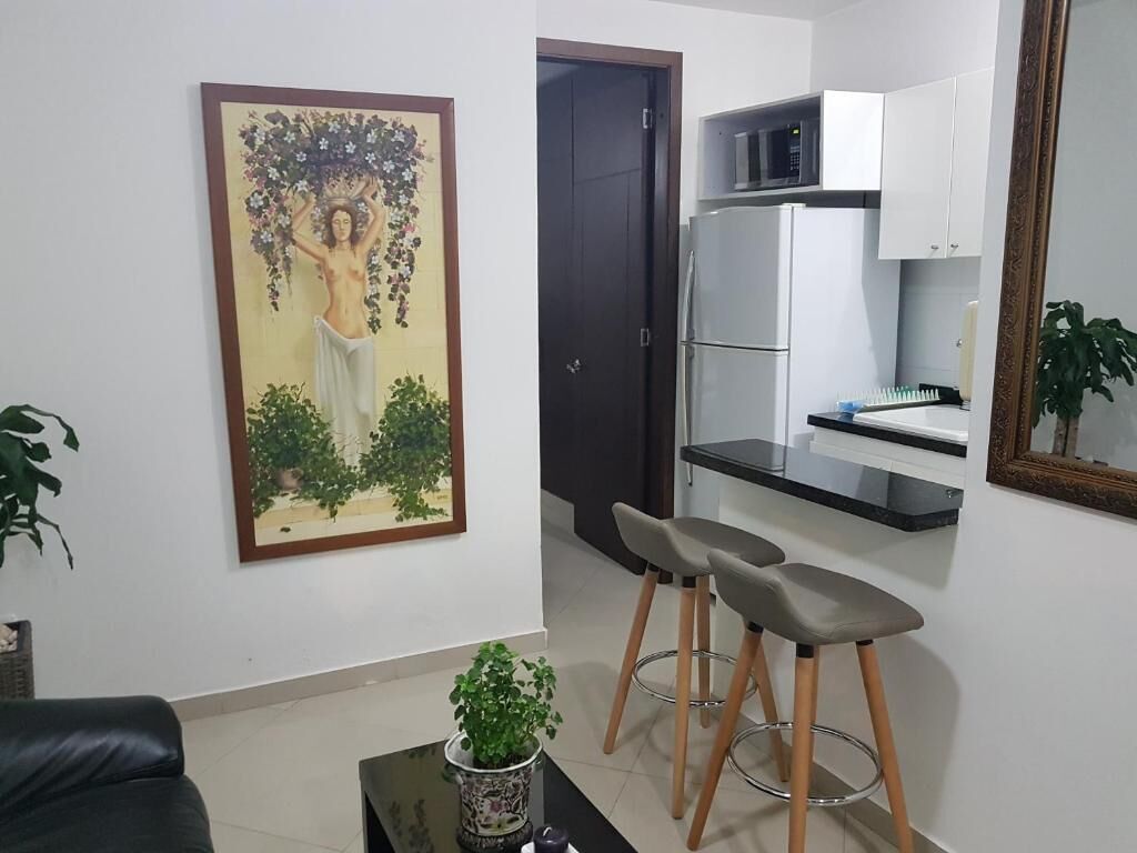 Una sala de estar con un cuadro, un sofá, una mesa de centro y una puerta.