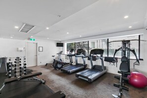 Ein Fitnessraum mit Laufbändern, Kraftgeräten und einem roten Trainingsball.