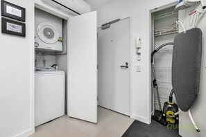Un cuarto de lavado con lavadora, secadora y aspiradora.